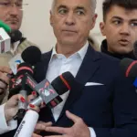 Колишній кандидат у президенти Келін Джорджеску спілкується з представниками ЗМІ після голосування на виборчій дільниці, 18